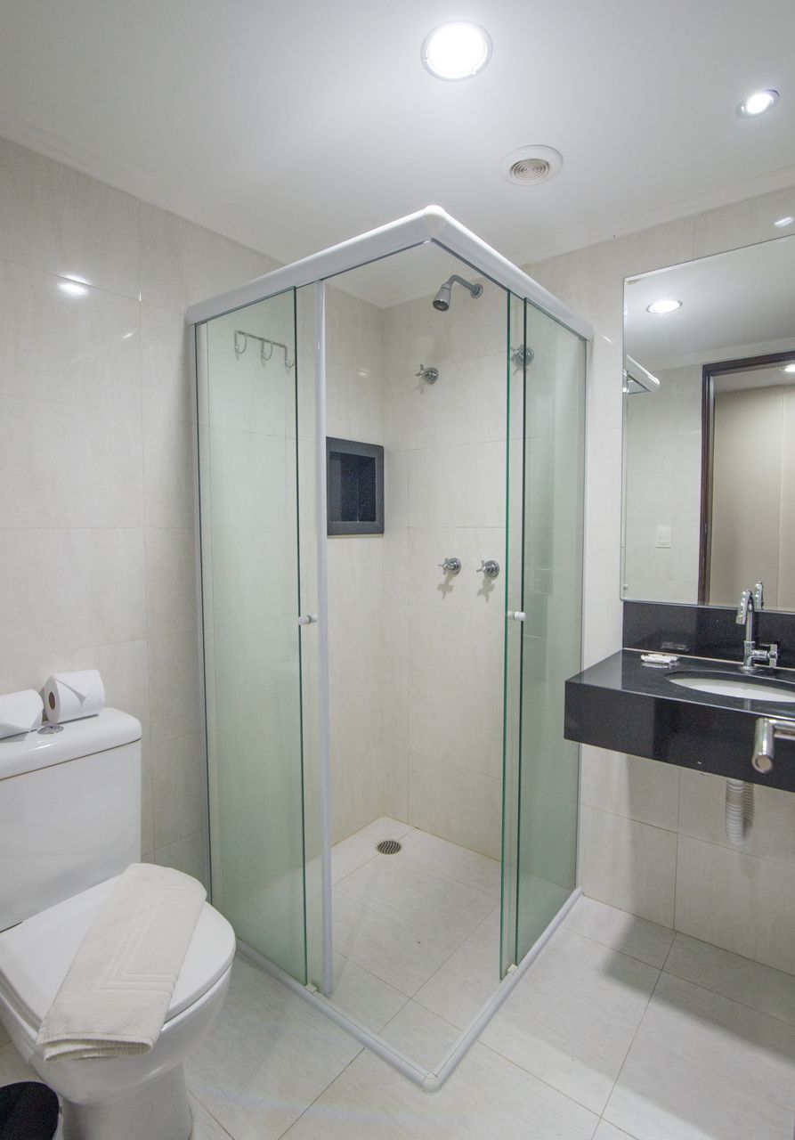 Une salle de bain moderne avec une douche à parois de verre, des toilettes et un lavabo avec un miroir.