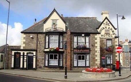 The Ivan Arms Hotel with a traditional stone facade, a signboard for breakfast, and a no entry sign visible.