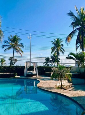 Alberca al aire libre, sombrillas en la alberca y camastros 