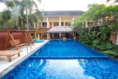 Una piscina al aire libre, sillones reclinables de piscina