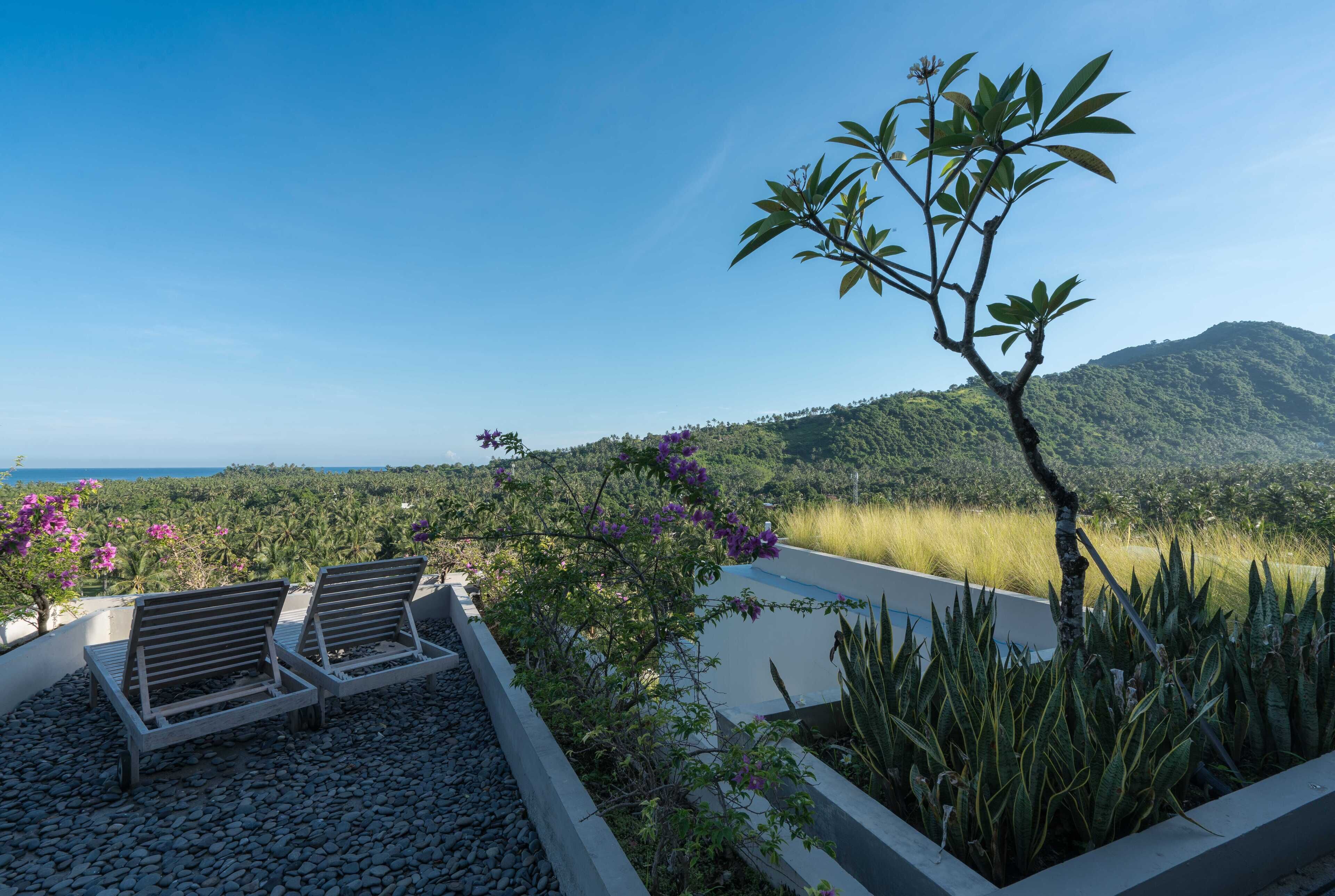 Un espace aménagé au bord de la piscine, avec des chaises longues, une petite piscine et une vue sur un paysage montagneux.