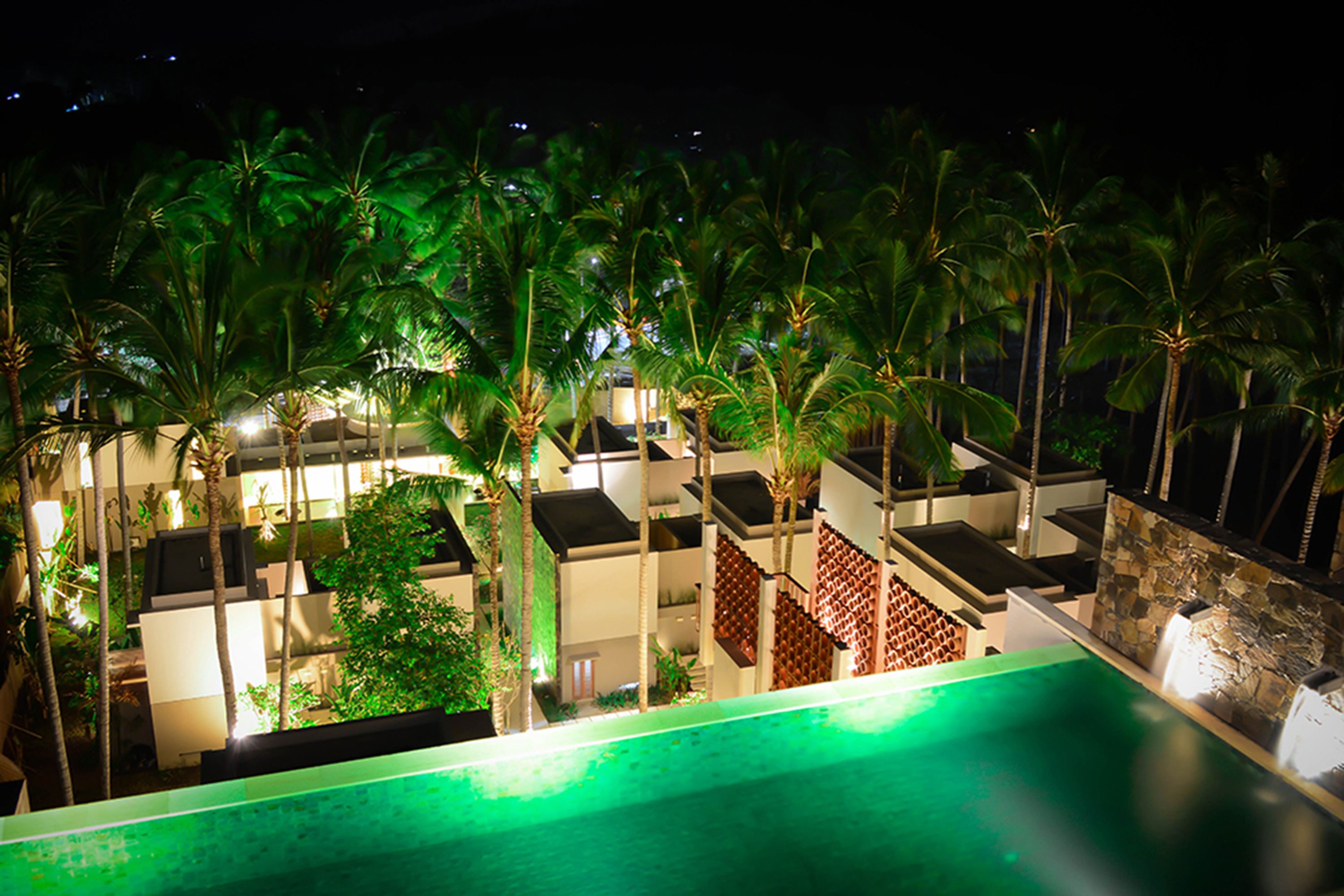 A poolside view of a resort with palm trees and a pool.