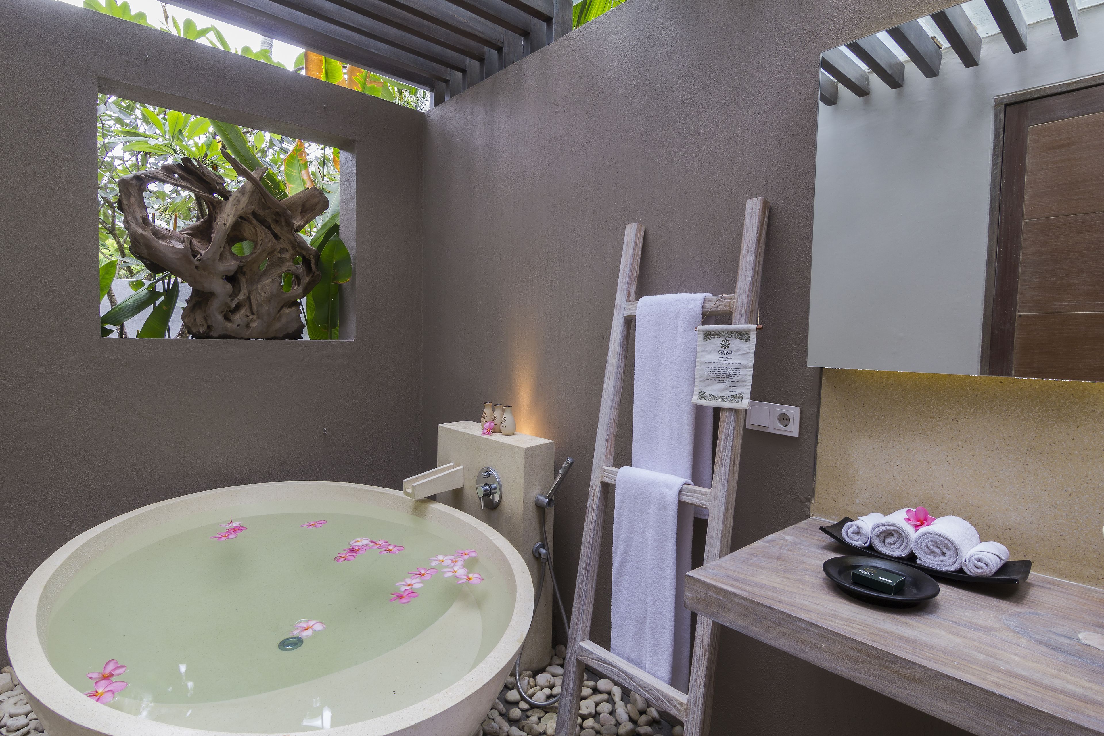 A bathroom with a freestanding bathtub, a wooden ladder, and a towel rack.