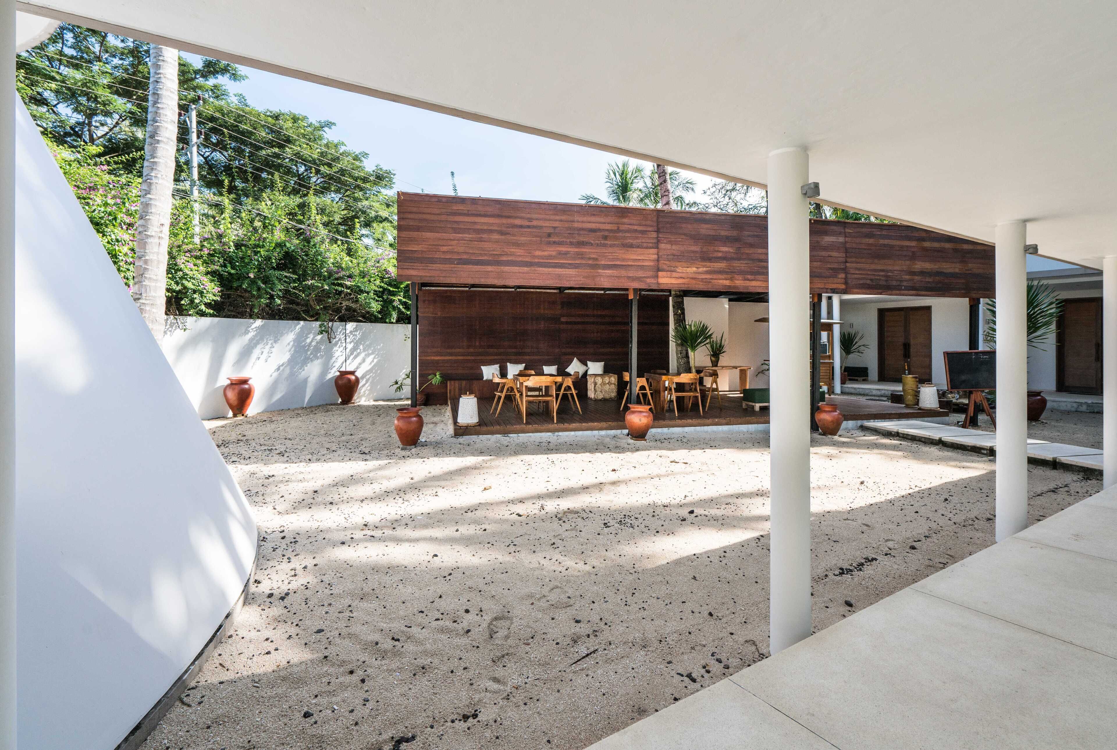 Ein Terrassenbereich im Freien mit einer modernen Holzterrasse, Sitzgelegenheiten und Blumentöpfen.