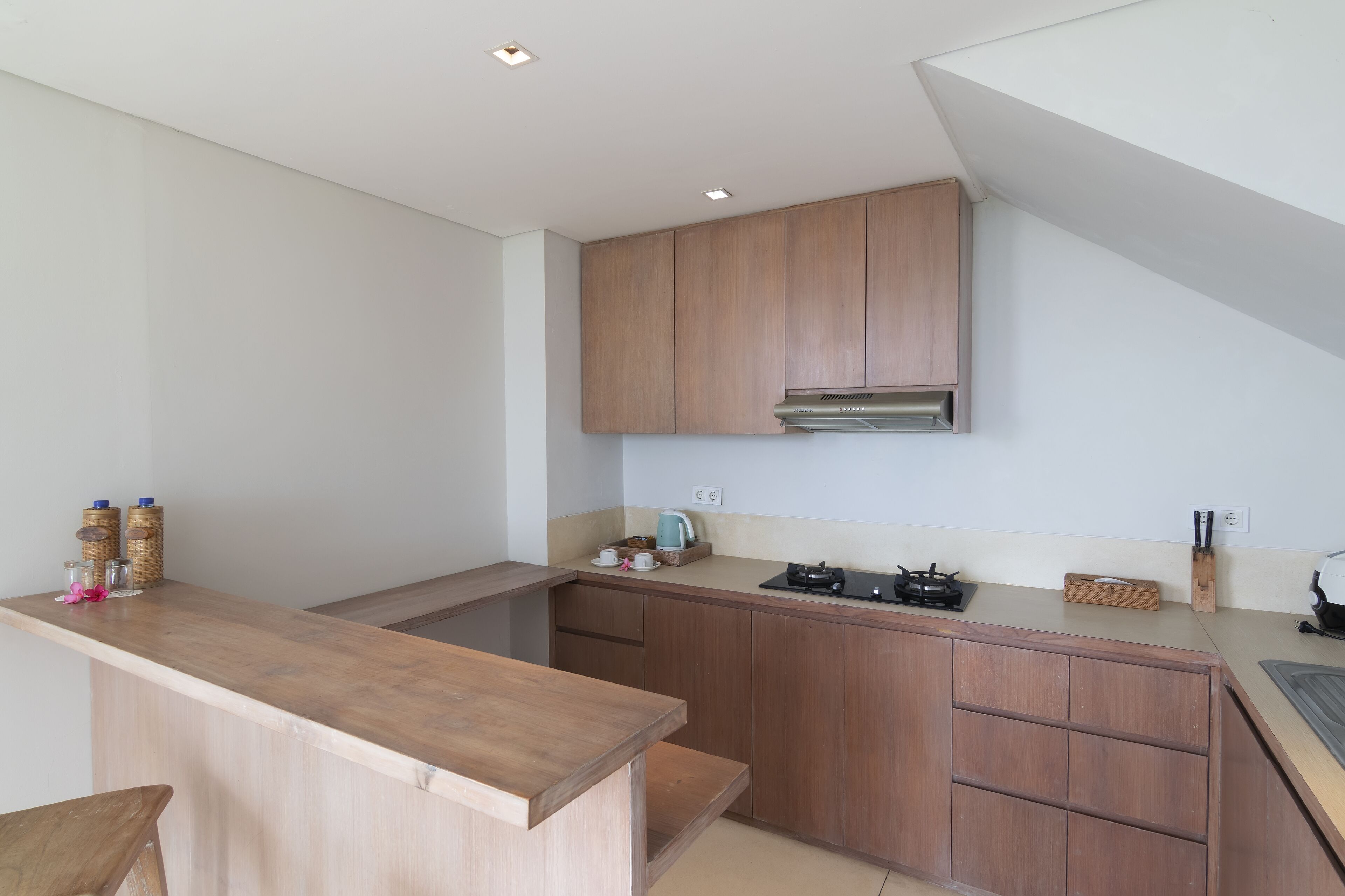 Een moderne keuken met houten kastjes, een aanrecht en een gasfornuis.