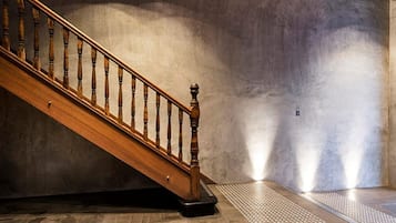 A wooden staircase with a handrail leading to a landing.