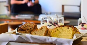 A tray with slices of bread and glasses of yogurt with fruit on a table.