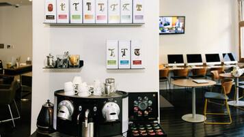 A modern coffee shop with a coffee machine, cups, and a display of coffee beans.