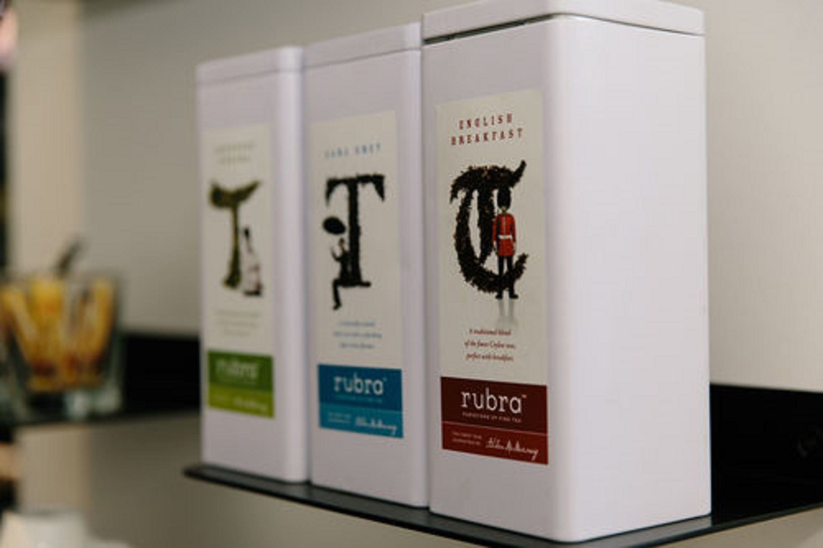 Tres cajas blancas con cubiertas de libros sobre una estantería.