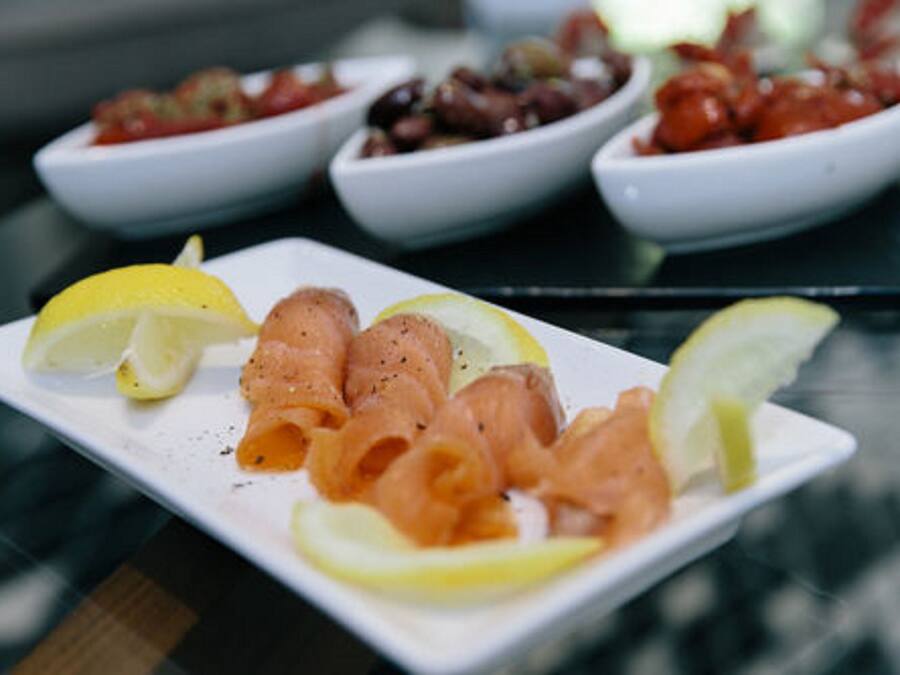 Un plato de salmón ahumado con rodajas de limón sobre una mesa.
