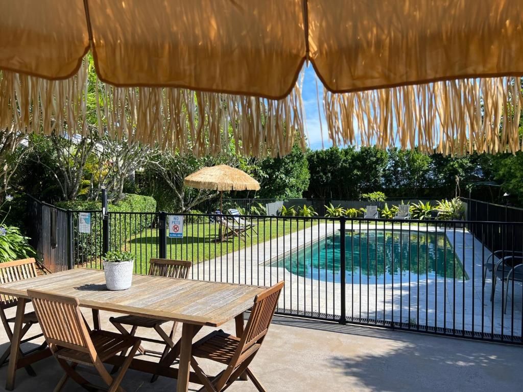 Patio esterno con piscina, circondato da recinzione e vegetazione.