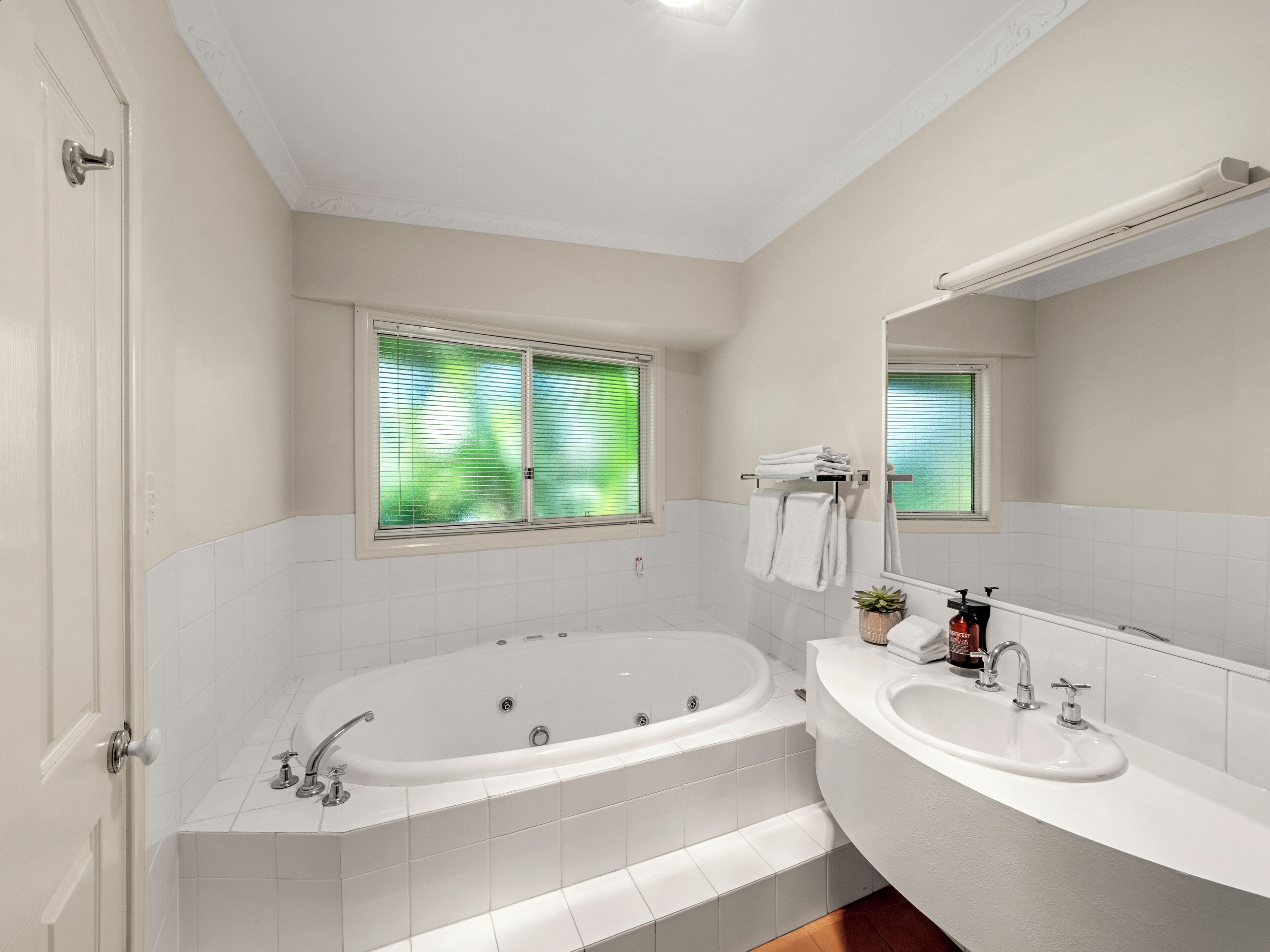 A modern bathroom with a freestanding bathtub, a vanity with a sink, and a large mirror.