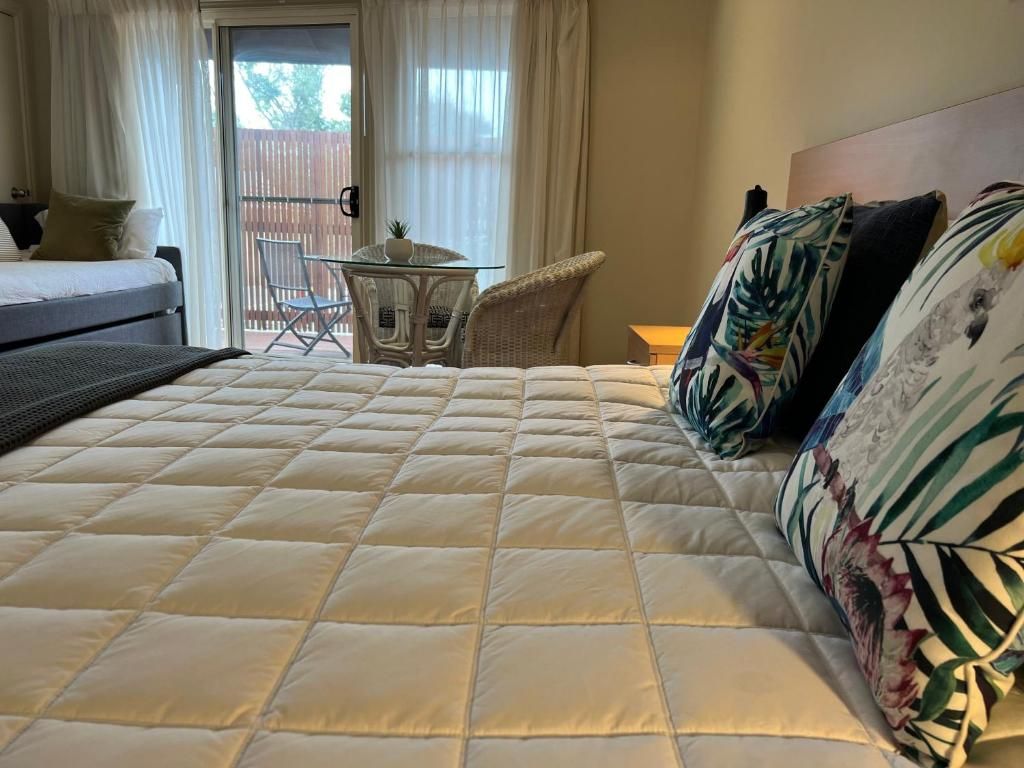 Une chambre d’hôtel avec un grand lit, une petite table et une chaise.