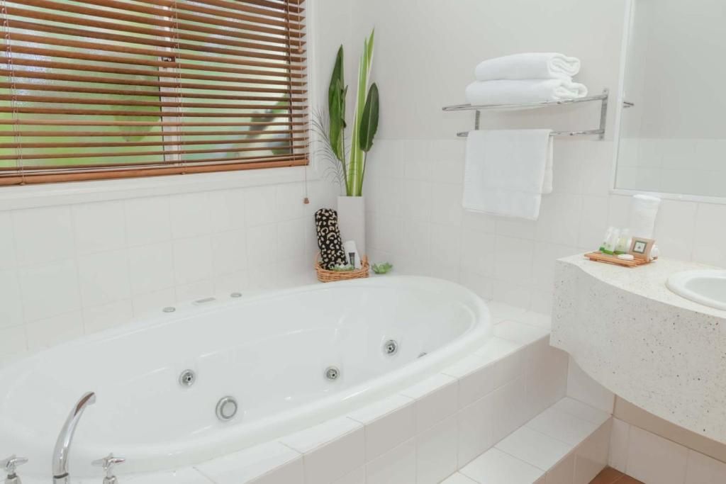 Ein Badezimmer mit einer weißen Badewanne, einem Waschbecken und einem Handtuchhalter.