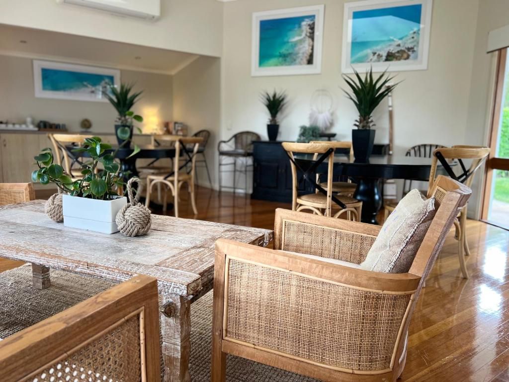 A dining area with wicker furniture and potted plants.