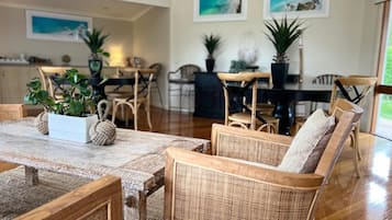 A dining area with wicker furniture and potted plants.