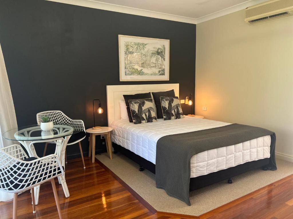 A bedroom with a bed, bedside tables, a chair, and a small table.
