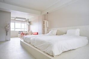A modern bedroom with a large bed, a desk, and a chair. - Hostel Casa Noda (Nagasaki)