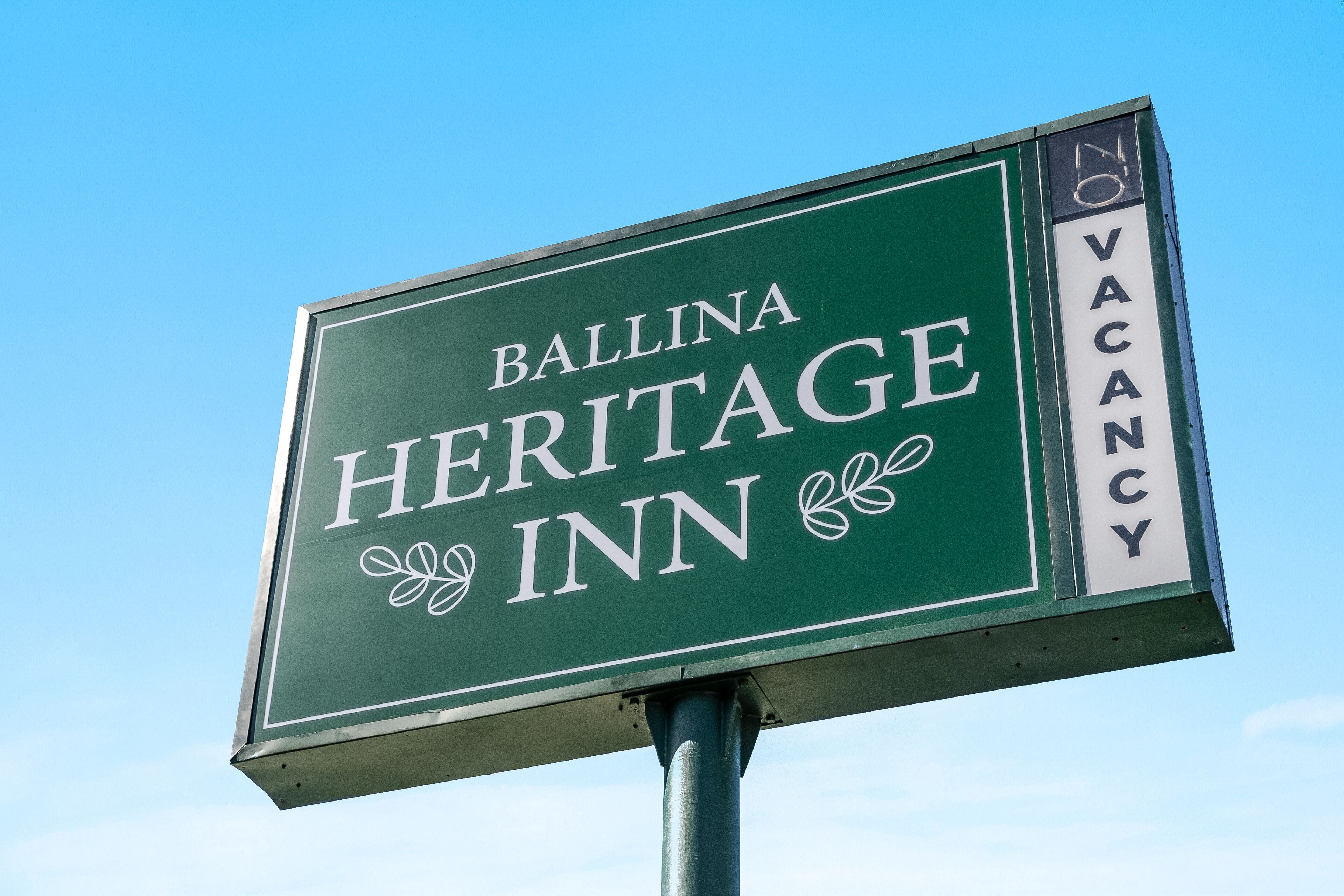 Une enseigne indiquant l’hôtel Ballina Heritage Inn, avec une affiche signalant qu’il y a des chambres disponibles.