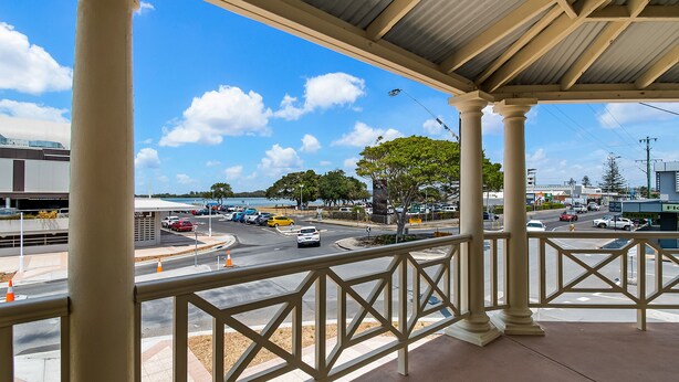A covered outdoor area with a view of a busy street and a body of water. - Ballina Heritage Inn (Ballina)