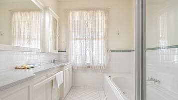 Un bagno con vasca, doccia, lavandino e specchio.
