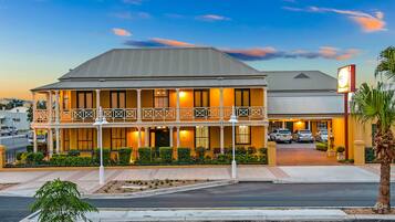 Vista frontal de la propiedad por la tarde o noche