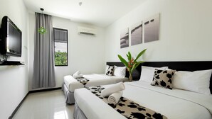 A hotel room with two beds, a TV, an air conditioning unit, and a window with curtains. - Riverra Inn Langkawi (Langkawi)