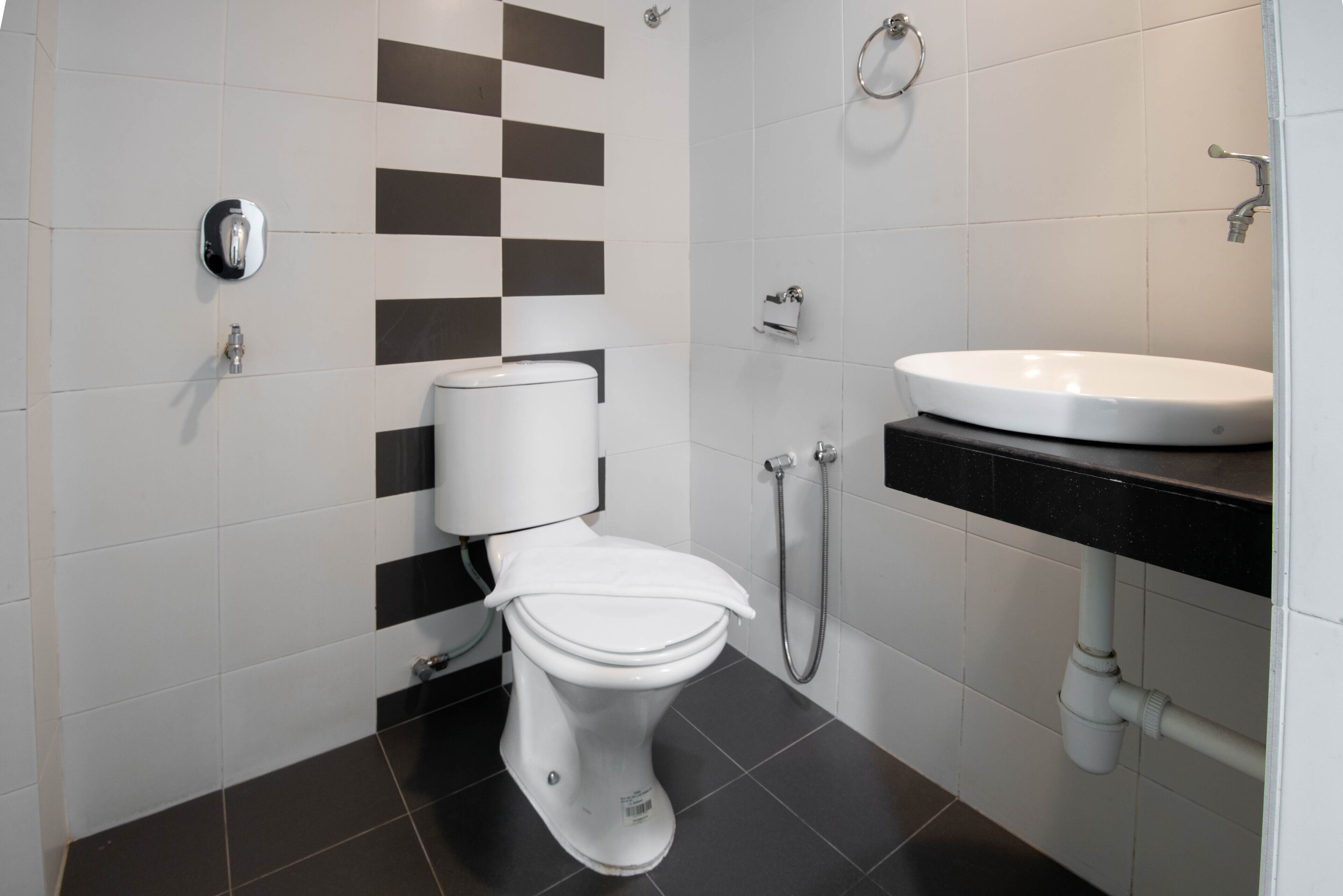 Et moderne badeværelse med toilet, vask og bruser.
