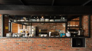A brick-walled kitchen with various appliances and utensils. - Riverra Inn Langkawi (Langkawi)