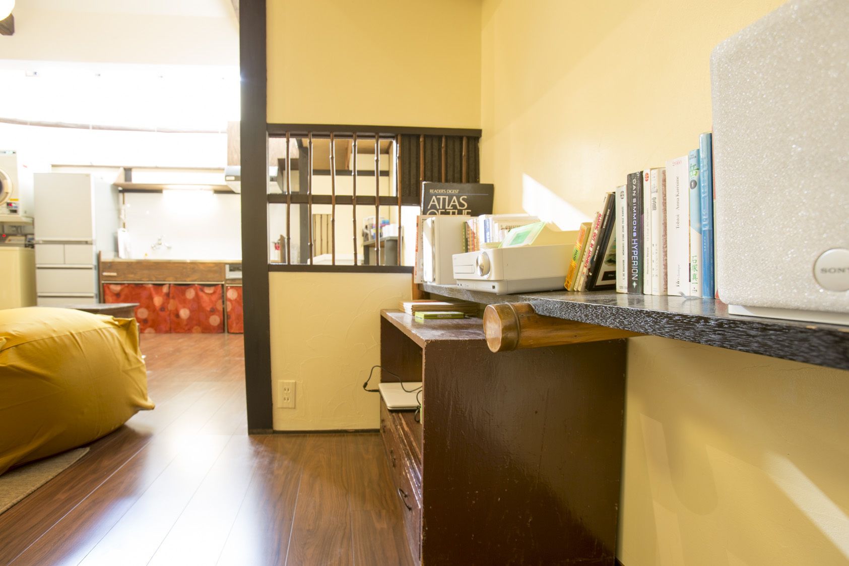 A compact kitchen with a microwave, a small refrigerator, and a wooden cabinet.