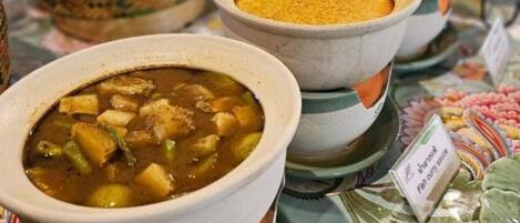 Variedad de platos, incluyendo un tazón de sopa con trozos, un tazón de curry y un tazón de arroz.