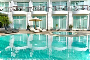 Una piscina al aire libre, sombrillas, tumbonas