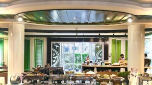 A buffet area with various food items and a counter with staff.