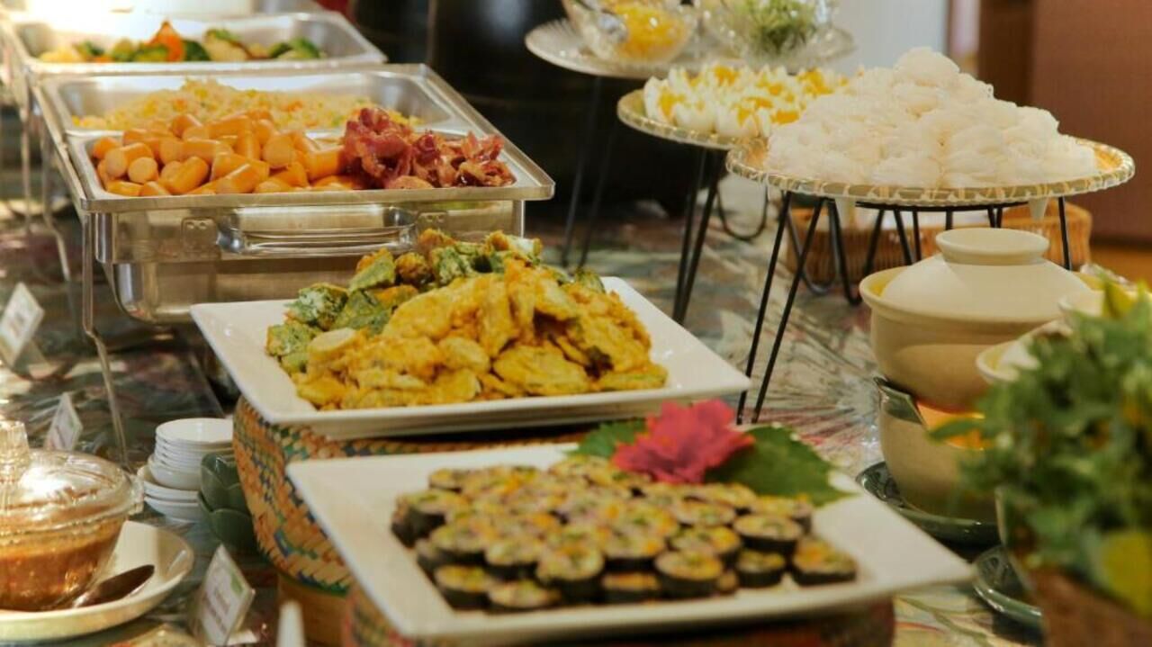 A buffet with various dishes including sushi, vegetables, and other prepared foods.