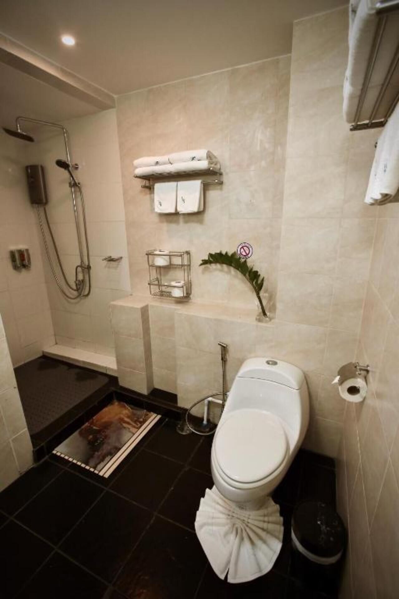 A bathroom with a shower, toilet, and sink.