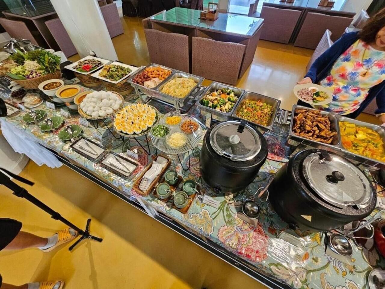 Un buffet proposant une variété de plats et une grande marmite placée sur le côté droit.