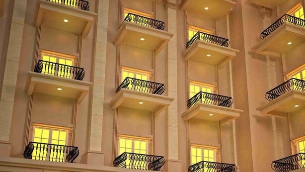 A multi-story hotel with balconies, warm lighting, and arched windows. - Bella Hotel Surabaya (Surabaya)