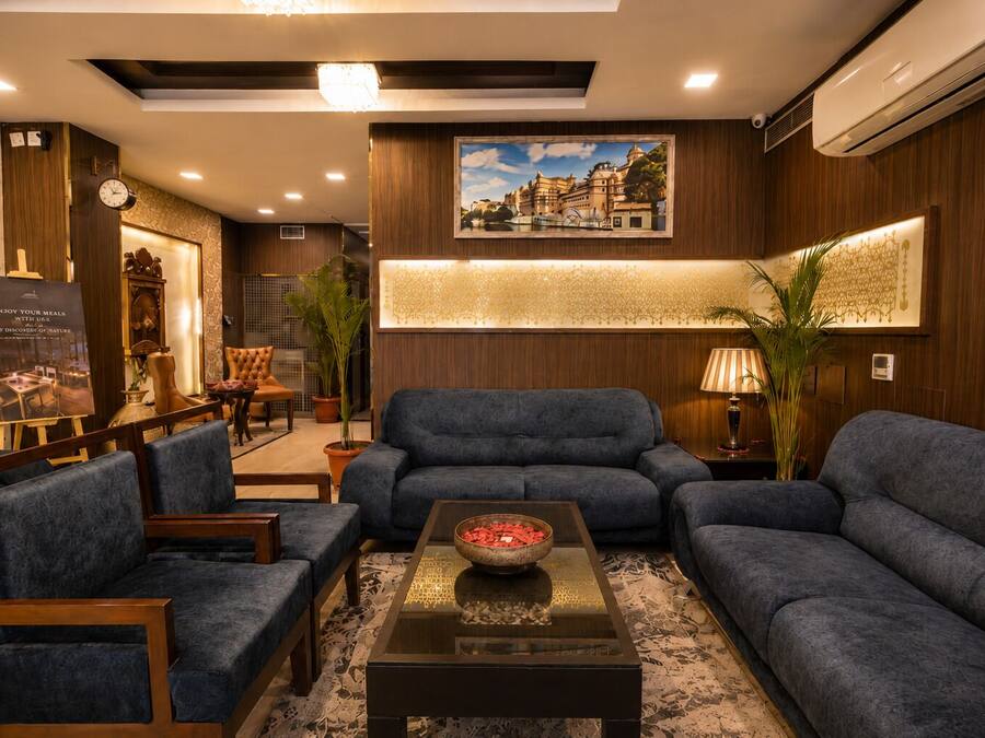 A modern lounge area with a sofa set, a coffee table, and a framed picture on the wall.
