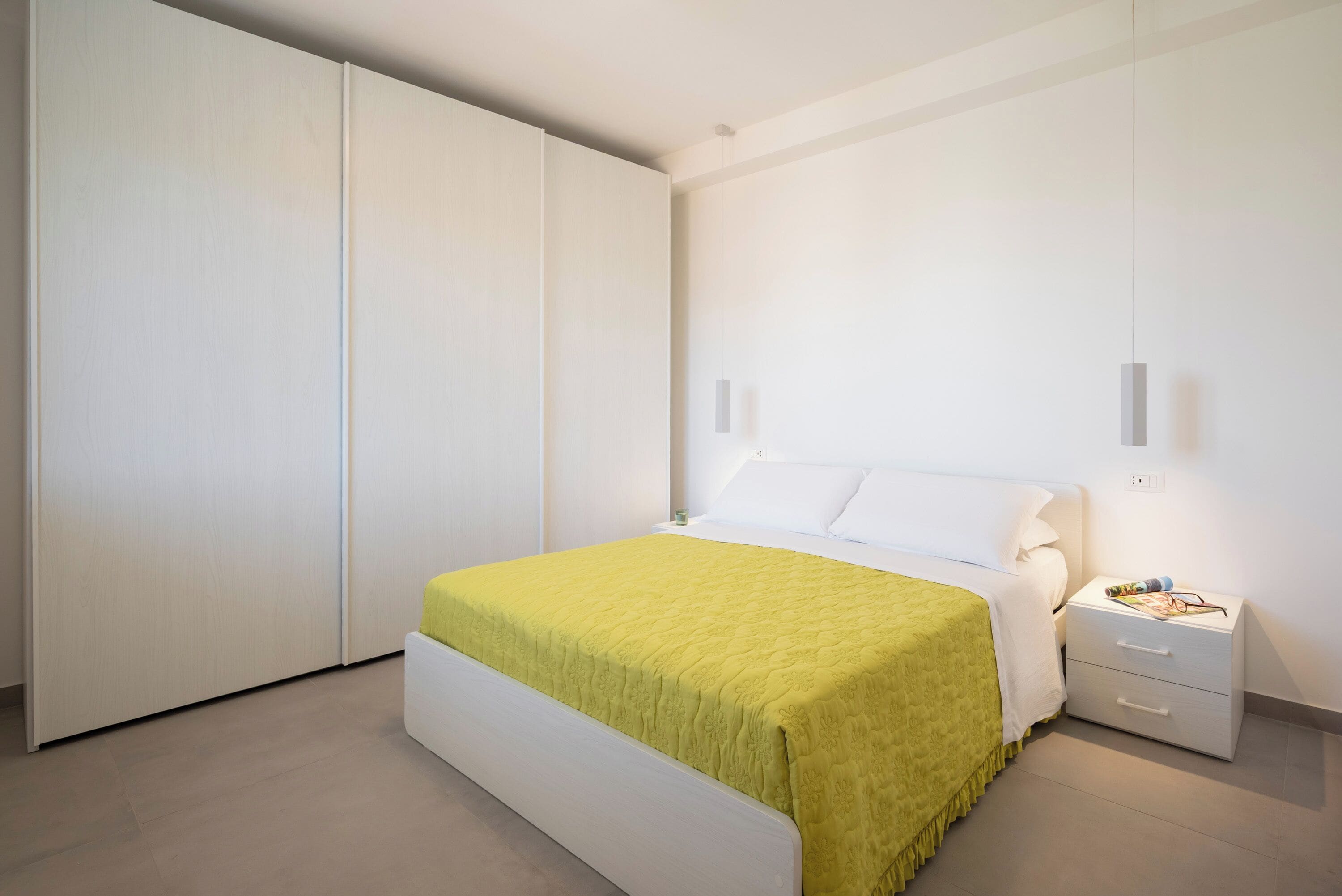 Un dormitorio con cama, mesita de noche y armario.
