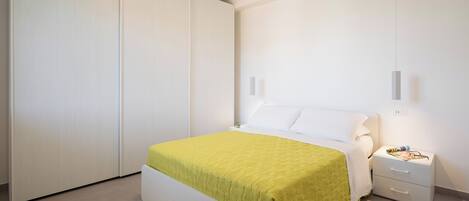 Un dormitorio con cama, mesita de noche y armario.