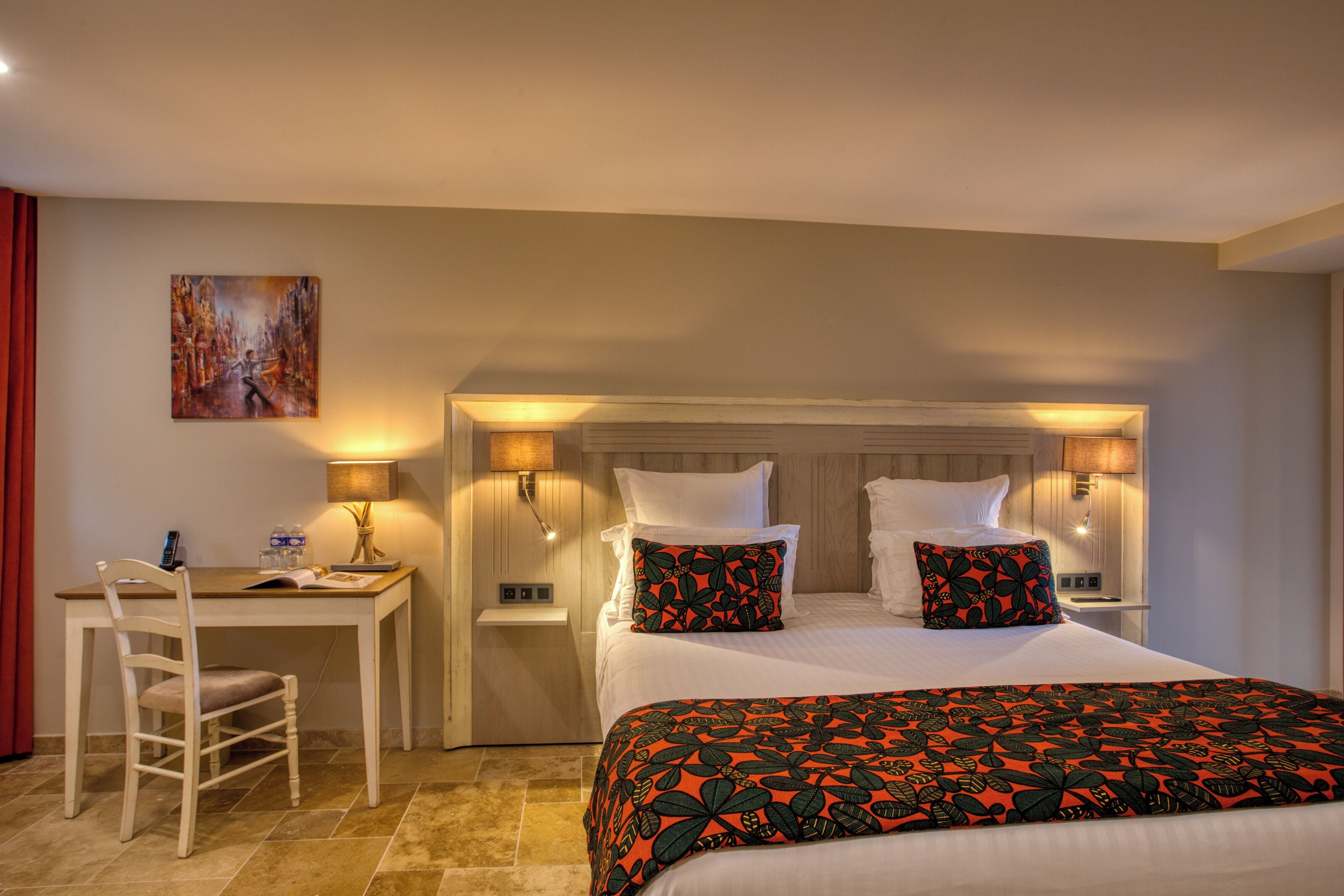 Une chambre d’hôtel avec un lit, des tables de chevet, un bureau et une chaise.