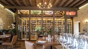 A restaurant with a wine cellar, wooden ceiling, and dining tables with chairs. - Domaine du Château de Monrecour – Hôtel et Restaurant (Saint-Vincent-de-Cosse)