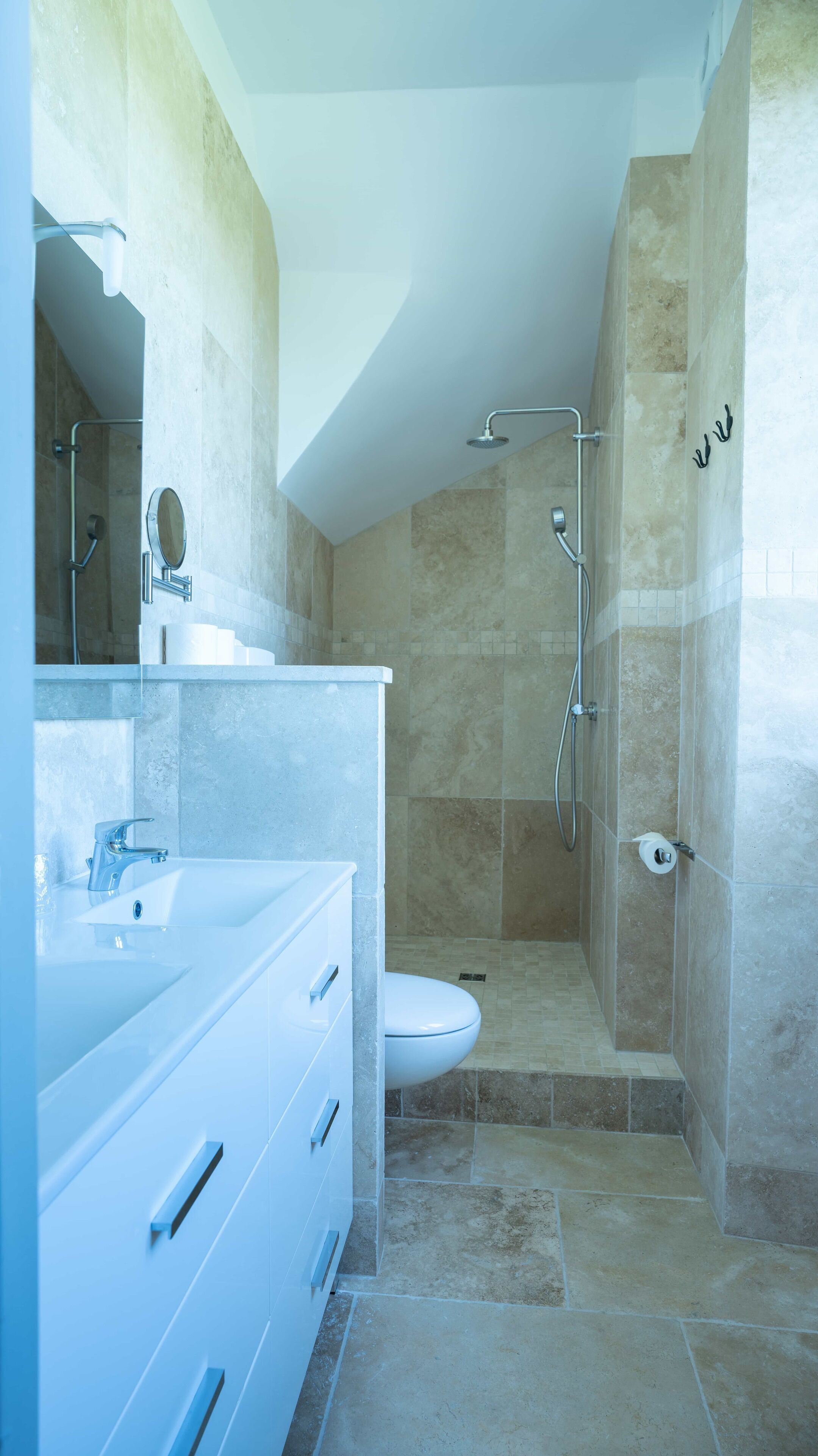A modern bathroom with a shower, toilet, and vanity.