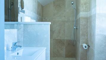 A modern bathroom with a shower, toilet, and vanity.