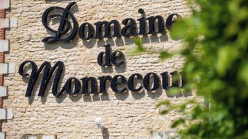 A stone building with the sign "Domaine de Monrecu."