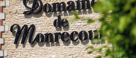 A stone building with the sign "Domaine de Monrecu."