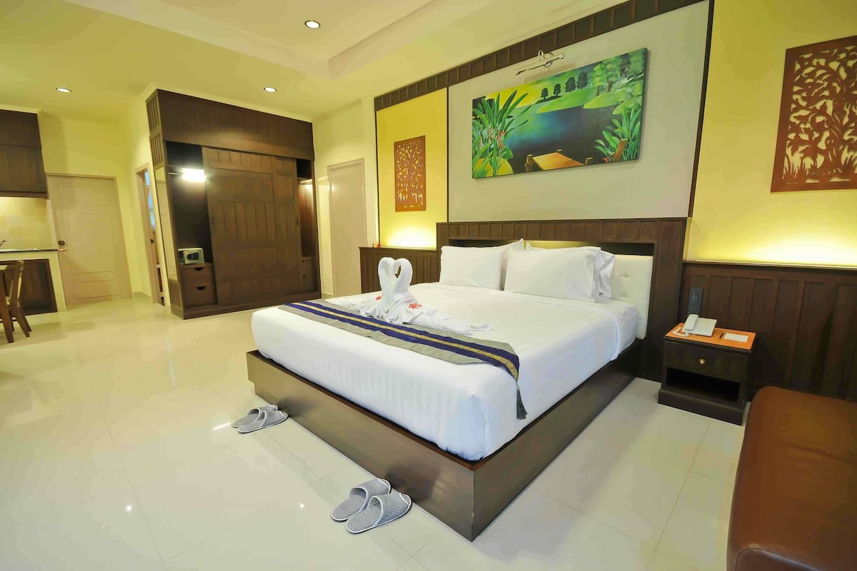 Habitación de hotel con una cama grande, una mesita de noche con teléfono y un cuadro en la pared.