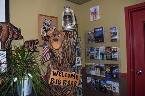 Un letrero de madera que dice 'Welcome to the Big Bear', con una figura de oso y un farol.