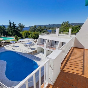 A rooftop pool area with a view of a lake and mountains. - Gran Hotel Casablanca (Villa Carlos Paz)