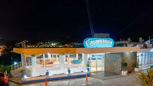 Un hôtel appelé « Casablanca », doté d’un design moderne, avec une façade en pierre et une enseigne lumineuse bien visible.